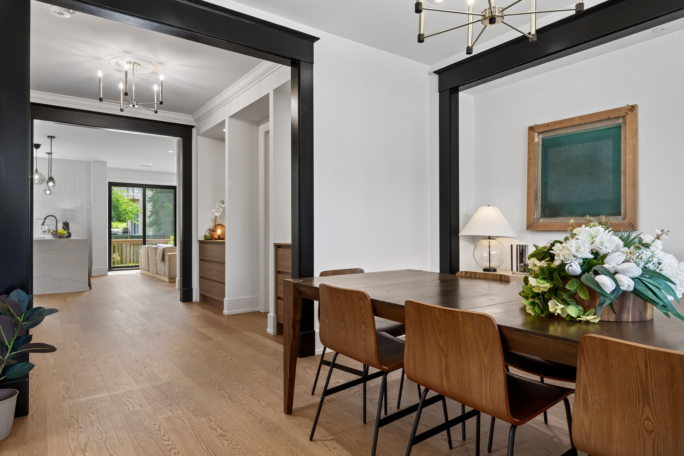 Wood dining table beside a sequence of dark framed doorways