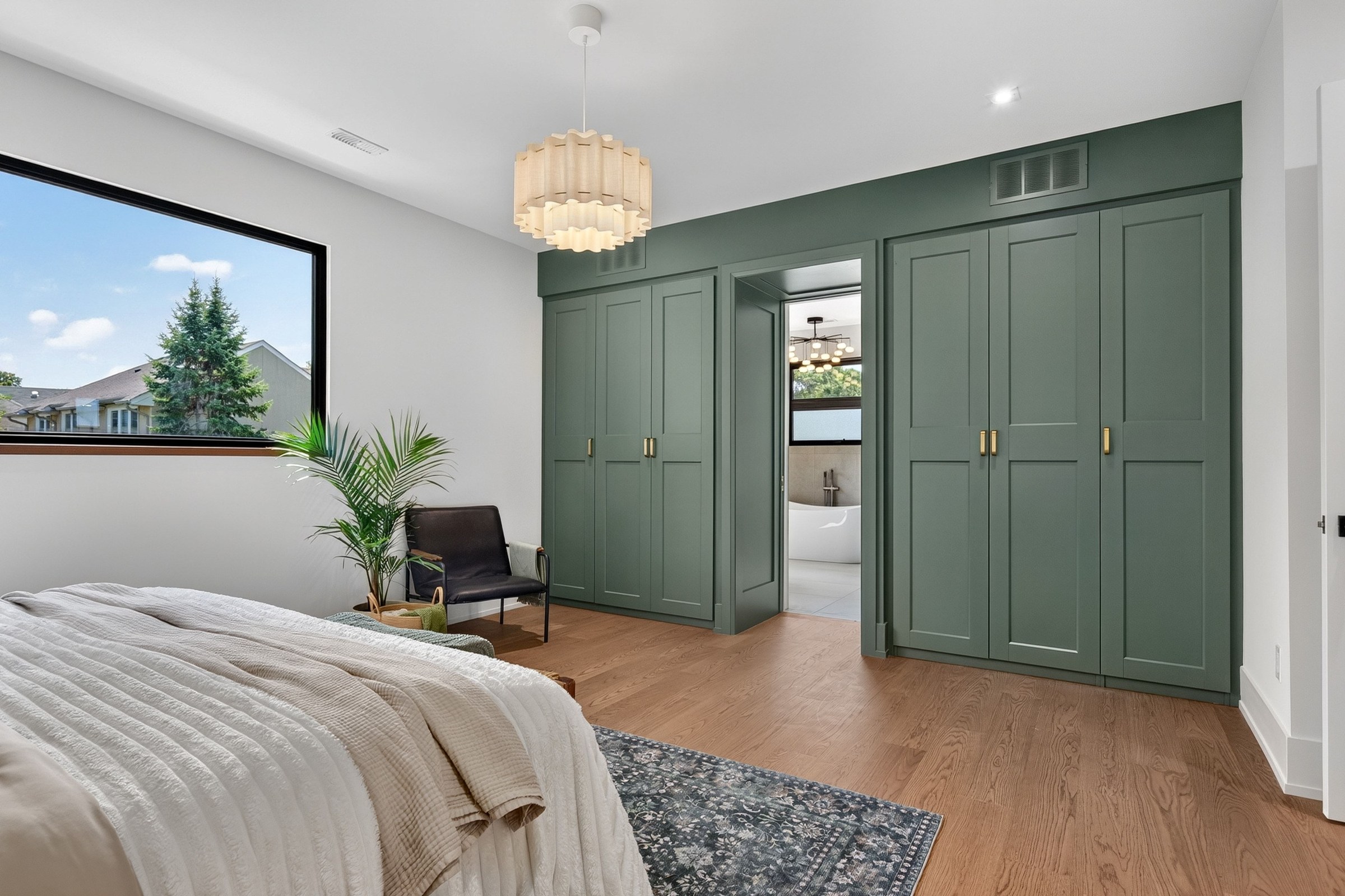 Green built-in bedroom cabinetry surrounding an open bathroom doorway