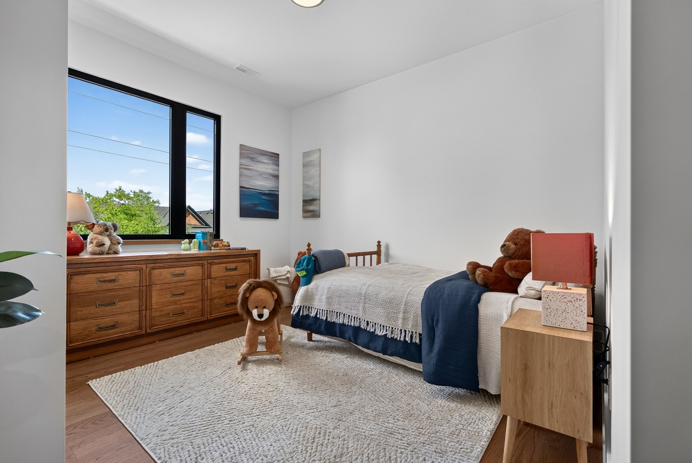 Children’s bedroom with a teddy bear, rocking lion and large window